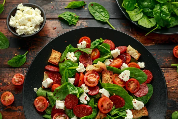 Салат из помидоров чоризо со шпинатом, сыром фета и гренками. здоровое питание летом — стоковое фото
