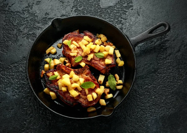 Chuletas de cerdo asadas con manzanas caramelizadas, nueces y salvia en una sartén de hierro fundido — Foto de Stock