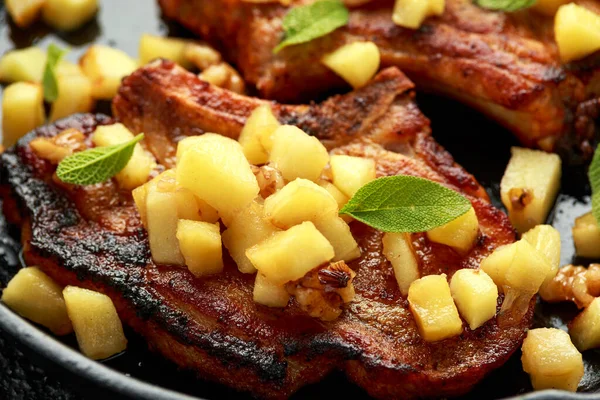 烤猪肉排骨，用焦糖化的苹果、核桃和鼠尾草放在铁锅里 — 图库照片
