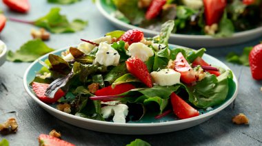 Keçi peyniri ve çilekli yaz salatası nigella ve susam tohumlarıyla servis edilir.