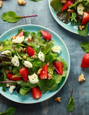Keçi peyniri ve çilekli yaz salatası nigella ve susam tohumlarıyla servis edilir.