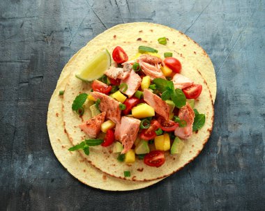 Mango, avokado, domates, taze soğan ve limonlu somon balıklı taco. Meksika yemeği
