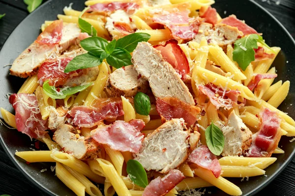 Pollo, tocino Penne pasta con queso parmesano y albahaca. alimentos saludables. —  Fotos de Stock