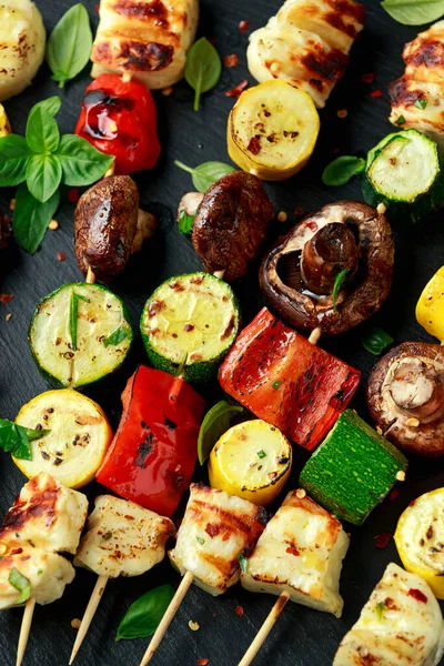Grilled Halloumi cheese skewers with vegetables on rustic stone board — Stock Photo, Image