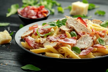 Tavuk, pastırmalı makarna, parmesan peynirli ve fesleğenli. sağlıklı yiyecekler.