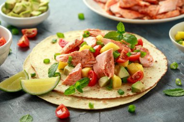 Mango, avokado, domates, taze soğan ve limonlu somon balıklı taco. Meksika yemeği