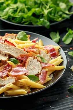 Tavuk, pastırmalı makarna, parmesan peynirli ve fesleğenli. sağlıklı yiyecekler.