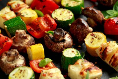 Izgara sebze ve mantarlı halloumi peyniri şişleri, kırmızı biber, kabak ve bitkiler.