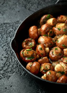 Demir tavada soğanlı ve sarımsaklı kızarmış mantar.