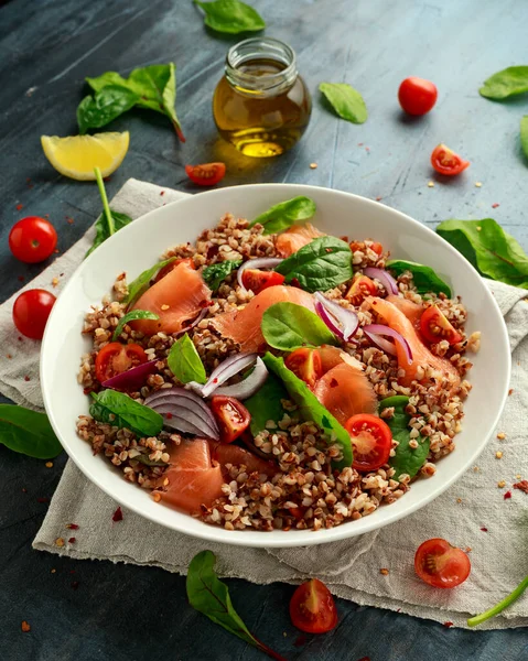 Салат из гречихи с копченым лососем, помидорами черри, красным луком и зеленью — стоковое фото