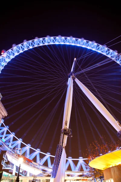 Night time view of the London Eye observation wheel illuminated with purple blue lighting — Stock Photo, Image