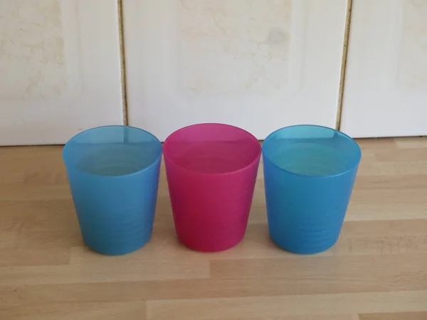 Ahşap mutfak atölyesinde üç renkli plastik deney şişesi.