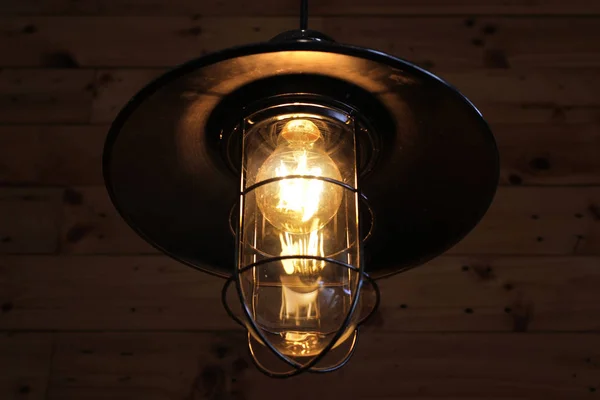 light bulbs in hanging lamp with wooden wall background