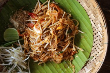 Tayland, tavada kızartılmış erişte dokuma ahşap plaka üzerinde karidesli yastık