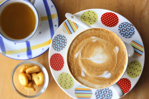 กาแฟคาปูชิโนเสิร์ฟพร้อมชาและคุ้กกี้ — ภาพถ่ายสต็อก