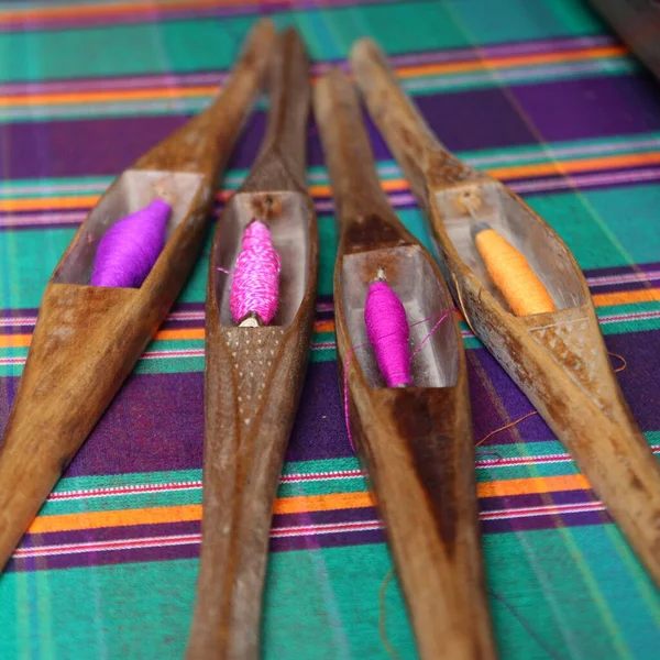 wooden bobbin on silk fabric, traditional weaving of Thai silk