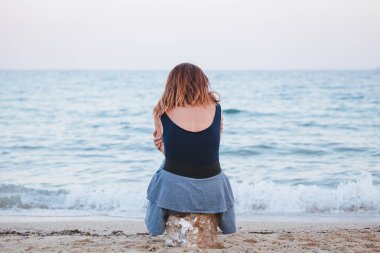 Yalnız ve depresyonda sahilde oturan kadın