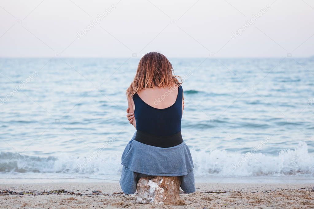 Woman alone and depressed sitting at the beach