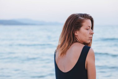 Yalnız ve depresyonda sahilde oturan kadın