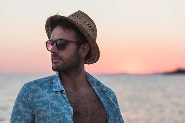 Young man enjoying sunset by the sea