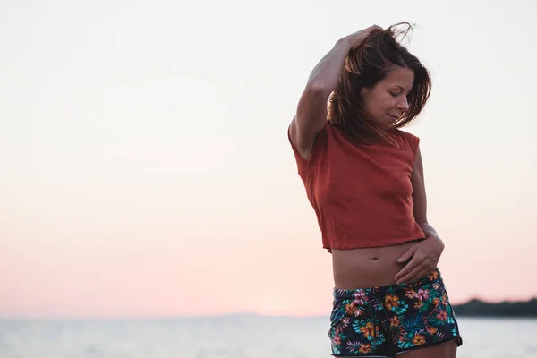 Νεαρή Γυναίκα Απολαμβάνει Ηλιοβασίλεμα Δίπλα Στη Θάλασσα — Φωτογραφία Αρχείου