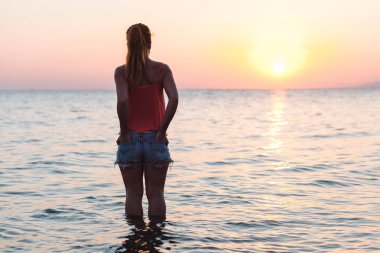 Genç kadının deniz ve gün batımı