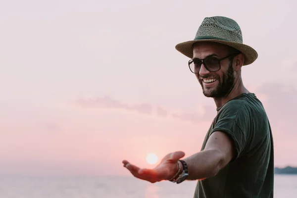 Young man enjoying sunset by the sea