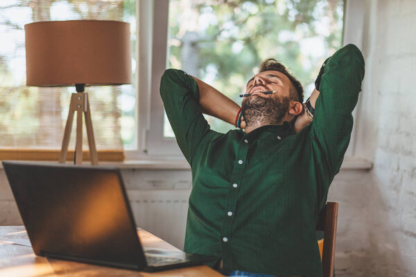 Young man having sressful time working on laptop