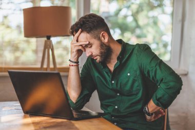 Genç adam üstünde Laptop çalışma sressful vakit geçiriyor