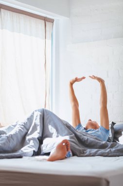 Genç kadın yatakta yatan uyanma