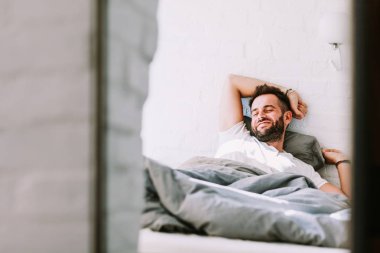 Genç adam yatakta sabah uyanma