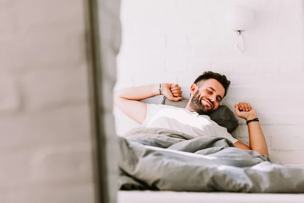 Genç adam yatakta sabah uyanma