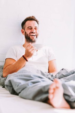 Genç adam yatakta kahve içme