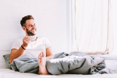 Genç adam yatakta kahve içme