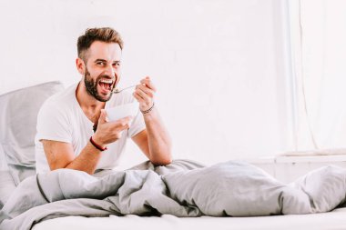 Yatakta genç adam yemek kahvaltı