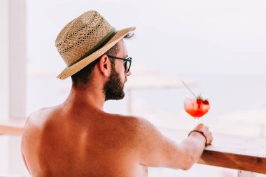 Genç adam bir plaj barda kokteyl zevk