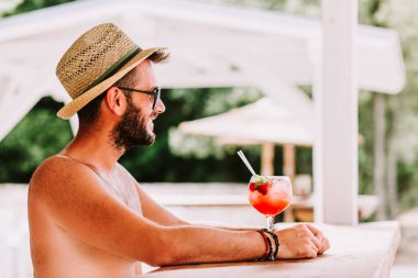 Genç adam bir plaj barda kokteyl zevk