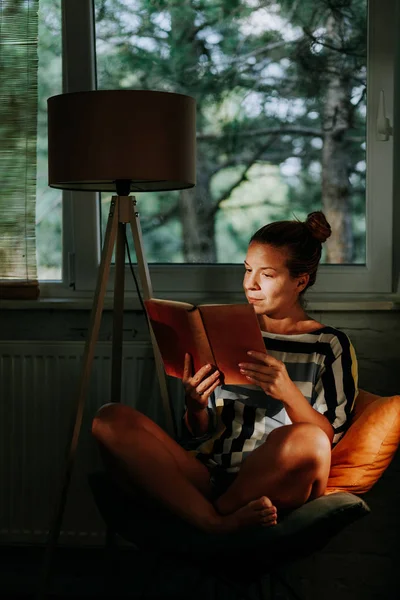 Giovane Donna Che Legge Libro Casa Vicino Alla Finestra — Foto Stock