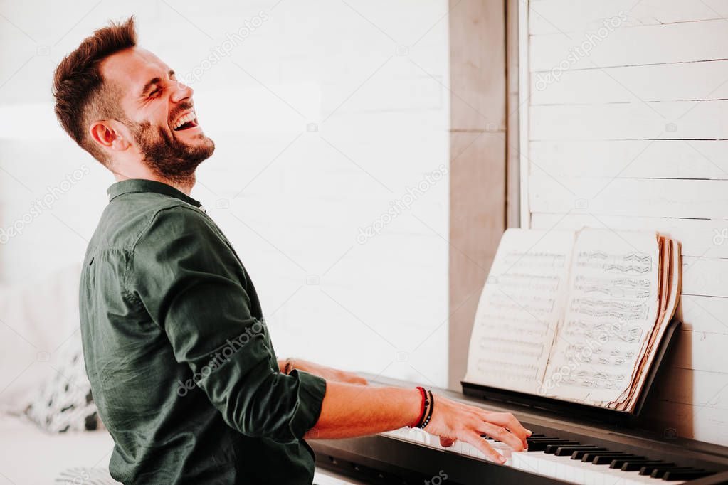 Young man playing electric piano at home