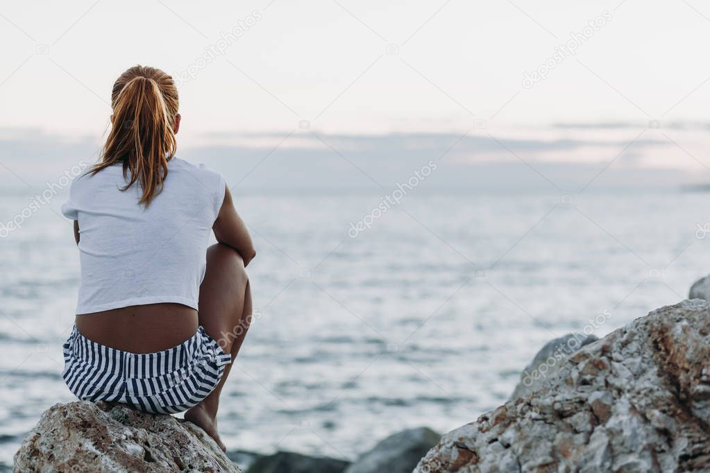 Woman alone and depressed sitting at the beach