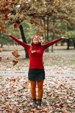 Genç kadın sonbahar atma park havada bırakır
