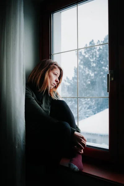 Smutna Kobieta Siedziała Przy Oknie Patrząc Poza — Zdjęcie stockowe