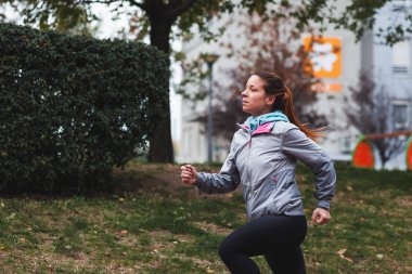 Kadın koşuyor. Kadın koşucu, maratona hazırlanıyor. Formda kız spor mankeni dışarıda egzersiz yapıyor..