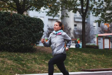 Kadın koşuyor. Kadın koşucu, maratona hazırlanıyor. Formda kız spor mankeni dışarıda egzersiz yapıyor..