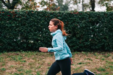 Kadın koşuyor. Kadın koşucu, maratona hazırlanıyor. Formda kız spor mankeni dışarıda egzersiz yapıyor..
