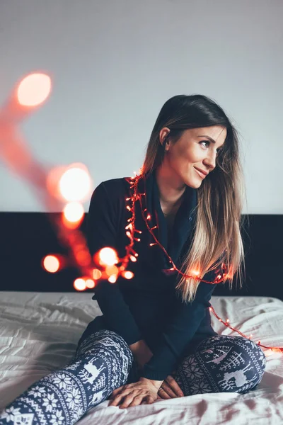 Young Woman Christmas Lights Sitting Bed — Stock Photo, Image