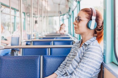 Genç kadın toplu taşıma içinde müzik dinlemek