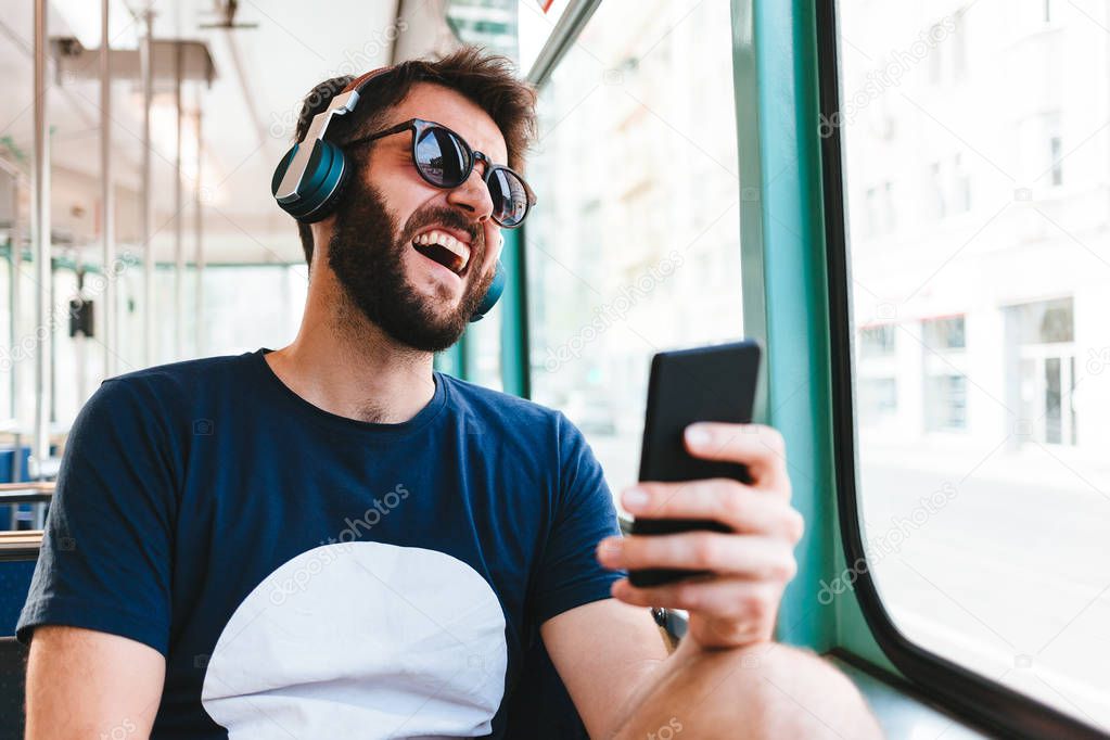 Young man riding in public transport listening to the music