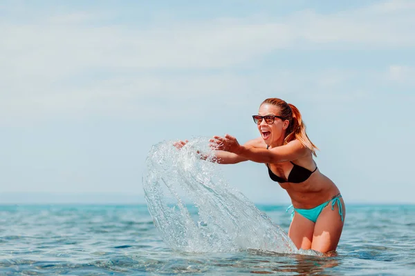 海の水と遊ぶ若い女性 — ストック写真