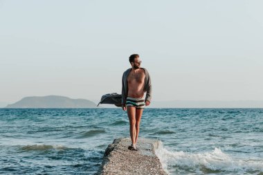 Sunset plajında bornozlu genç adam